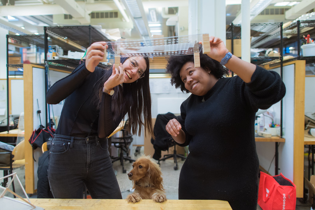 Two students hold up an architectural model.