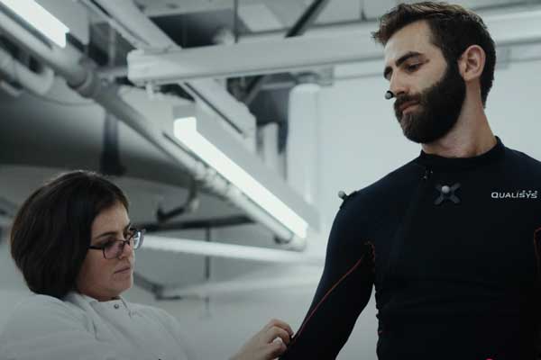 A medical professional fitting a sensor suit a person