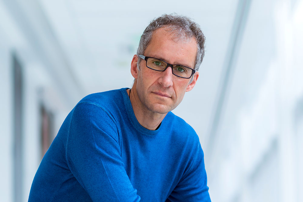 Male professor, Jacopo Buongiorno in hallway with glass windows