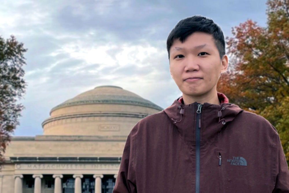 Yu-Jou Wang outdoors in front of an MIT building with a dome